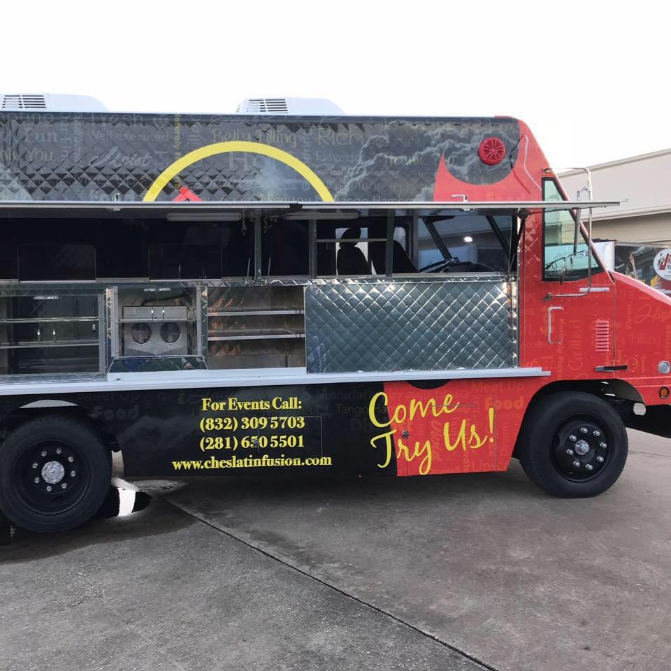 Che's red and black fusion truck parked outside a shop