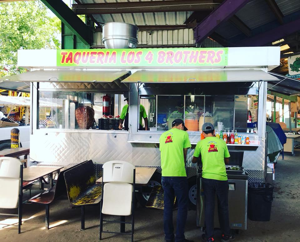 Three employees in action at 'Taqueria Los 4 Brothers' truck